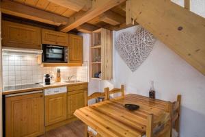 a kitchen with a wooden table and a kitchen with a tableablish at Cocoon In Megève in Megève +4 photos