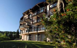 a large apartment building with a tree in front of it at Résidence Le Pédrou - maeva Home - Studio 2 Personnes - Confort MAE-3956 in Font Romeu Odeillo Via +12 photos