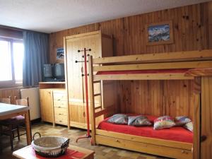 a bedroom with a bunk bed with a red bedspread at LE VERCORS - Appartement VERCORS 111 pour 4 Personnes 98 in Plagne Villages