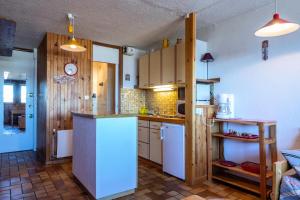 a kitchen with a refrigerator and a counter top at LE VERCORS - Appartement VERCORS 111 pour 4 Personnes 98 in Plagne Villages