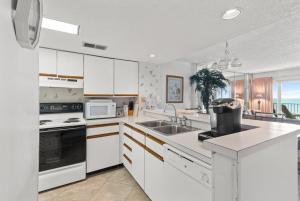 a kitchen with white cabinets and a sink at Carolina Dunes Unit 503 in Myrtle Beach