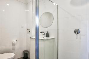 Charming 2 Bedroom House Surry Hills في سيدني: حمام مع دش مع حوض ومرآة
