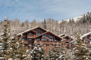 eine Blockhütte im Schnee mit Bäumen in der Unterkunft Résidence Les Fermes de Méribel - maeva Home - Appartement 2 Pièces 4 Pers 17 in Les Allues