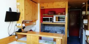 eine kleine Küche mit einem Schreibtisch und einem Waschbecken in der Unterkunft Résidence Aiguille Grive Bat Ii - 2 Pièces pour 5 Personnes 75 in Arc 1800