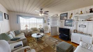 sala de estar con sofá y TV en Terrapin Cove in Cherry Grove, en Myrtle Beach
