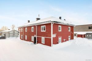 un bâtiment en briques rouges avec de la neige au sol dans l'établissement Rum i Kalix, à Kalix