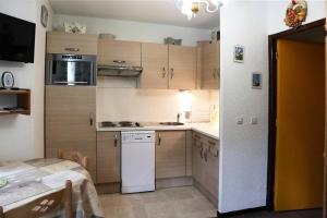 kuchnia z drewnianymi szafkami i białą lodówką w obiekcie Résidence Balcon Orres - NOUVEAUTE confortable studio 4 personnes MAE-4144 w mieście Le Mélézet +7 zdjęć