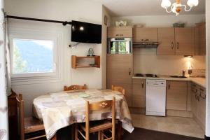 a small kitchen with a table and a window at Résidence Balcon Orres - Studio pour 4 Personnes 144 in Le Mélézet