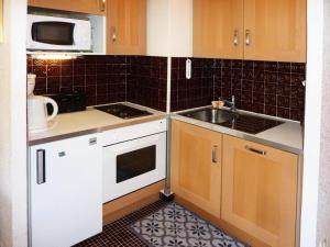a small kitchen with a sink and a microwave at Résidence Le Sunny Snow - Résidence Le Sunny Snow à deux pas du centre de la MAE-4164 in Le Mélézet