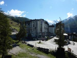 a view of a city with a building and mountains at Résidence Le Sunny Snow - Résidence Le Sunny Snow à deux pas du centre de la MAE-4164 in Le Mélézet