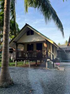ein Haus mit einer Palme davor in der Unterkunft Mango House in Ko Lanta