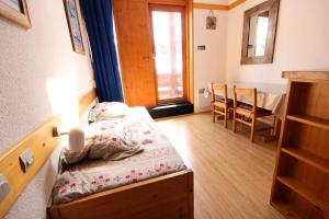 een kleine kamer met een bed en een eettafel bij Résidence Arc En Ciel - 2 Pièces pour 5 Personnes 63 in Peisey-Nancroix