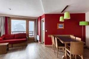 uma sala de estar vermelha com um sofá vermelho e uma mesa em Résidence Le Christiana - maeva Home - Appartement 2 Pièces 7 Personnes - S 12 em Saint-Bon-Tarentaise