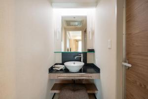 a bathroom with a sink and a mirror at New Otani Inn Sapporo in Sapporo