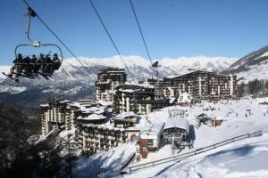 a group of people riding a ski lift in the snow at Résidence Le Pouzenc - Studio pour 4 Personnes 824 in Le Mélézet