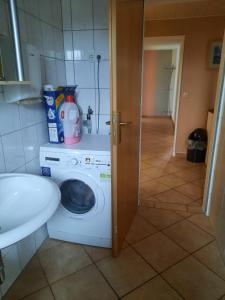 a bathroom with a washing machine and a sink at Familienfreundliche Wohnung in Schortens