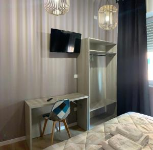 1 dormitorio con escritorio, 1 cama y TV en LAME 46 ROOMS en Bolonia