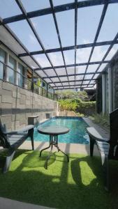 a patio with a table and two chairs and a pool at De Marlin's with Private Pool by GroRental in Tegalharendong