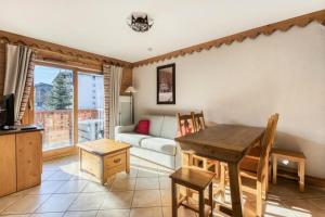 ein Wohnzimmer mit Tisch und Couch in der Unterkunft Résidence Les Fermes du Soleil - maeva Home - Appartement 3 Pièces 6 Personnes - Sélection MAE-6505 in Les Carroz d'Araches