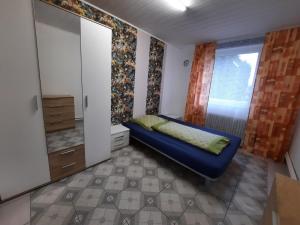 ショルテンスにあるFamilienfreundliche Wohnungのベッドルーム(青いソファ、窓付)