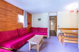 een woonkamer met een rode bank en een tafel bij LAUZES G - Appartement LAUZES 45 pour 5 Personnes 83 in Valmorel