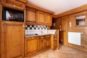 eine Küche mit Holzschränken und einem Waschbecken in der Unterkunft Résidence Les Alpages de Chantel - maeva Home - Appartement 4 Pièces 8 Pers 07 in Bourg-Saint-Maurice