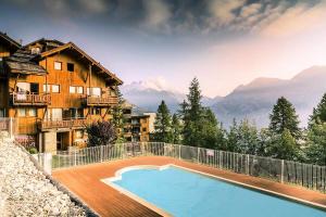 a house with a swimming pool in front of a mountain at Résidence Le Hameau des Ecrins - maeva Home - Appartement 2 Pièces 6 Person 50 in Puy-Saint-Vincent