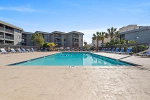 a swimming pool with chairs and a building at Sea Cabin Unit 125 Cherry Grove in Myrtle Beach