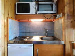 アルク1600にあるRésidence Cachette - Appartement 2 pièces 4 personnes à Arc 1600 en centre station proche des pistes et des commerces MAE-2095のシンクと電子レンジのある小さなキッチン