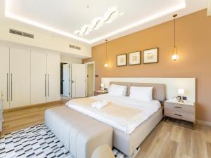 a large bedroom with a large white bed in it at FAM Living - Stunning 2 Bedroom Home In JBR in Dubai