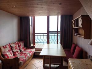 salon z kanapą i stołem w obiekcie Résidence Vogel - Chaleureux duplex pour 4 personnes avec une très belle vue sur la vallée dans le village de Charmettoger à Arc 1800 MAE-2129 w mieście Arc 1800
