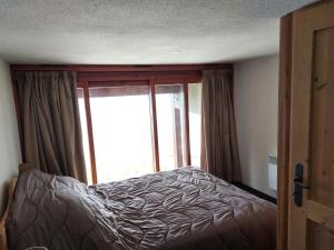 Łóżko lub łóżka w pokoju w obiekcie Résidence Vogel - Chaleureux duplex pour 4 personnes avec une très belle vue sur la vallée dans le village de Charmettoger à Arc 1800 MAE-2129