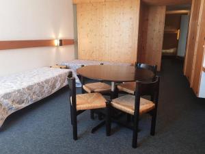Cette chambre comprend deux lits, une table et des chaises. dans l'établissement Résidence Cascade - Studio pour 4 Personnes 19, à Arc 1600