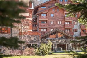 ein großes Holzgebäude mit Balkonen darauf in der Unterkunft Résidence Les Fermes du Soleil - maeva Home - Appartement 3 pièces 6 personnes - Sélection MAE-8007 in Les Carroz d'Araches