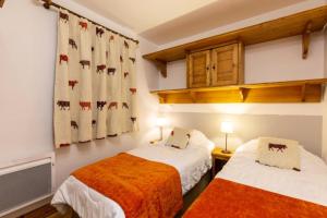 ein Schlafzimmer mit zwei Betten und einem Fenster in der Unterkunft Résidence Les Fermes du Soleil - maeva Home - Appartement 3 pièces 6 personnes - Sélection MAE-8004 in Les Carroz d'Araches