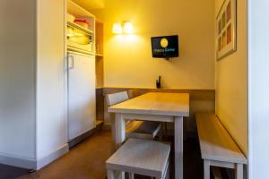 a table and benches in a room with a refrigerator at Résidence Plagne Lauze - maeva Home - Appartement 2 pièces 5 personnes - Confort MAE-9202 in Mâcot La Plagne