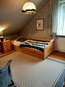 1 dormitorio con cama de madera y silla en Ferienwohnung Sankt Hubertus, en Bad Berneck im Fichtelgebirge