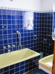 a blue tiled bathroom with a tub and a sink at Ferienwohnung Sankt Hubertus in Bad Berneck im Fichtelgebirge
