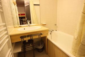 a bathroom with a sink and a tub and a mirror at Résidence Grande Ourse - 2 Pièces pour 4 Personnes 40 in Peisey-Nancroix