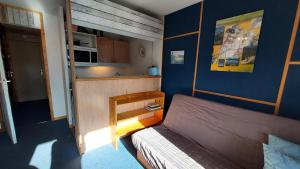 1 dormitorio pequeño con 1 cama y cocina en CHEVAL BLANC G - Appartement CHEVAL BLANC C63 pour 5 Personnes 56, en Valmorel