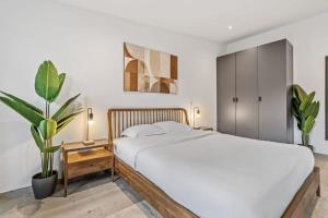 1 dormitorio con cama blanca y maceta en Luxurious 2BR Apt with Balcony in Luxembourg, en Luxemburgo