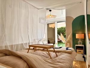 a bedroom with a table on top of a bed at Super Mini Loft avec Cinéma et Jardin - Cap d'Agde in Cap d'Agde