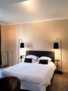 a bedroom with a large white bed with two pillows at Domaine de Joinville in Eu