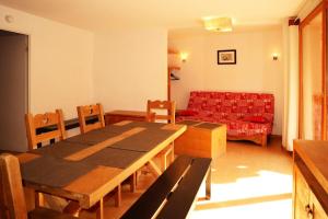 salon ze stołem i czerwoną kanapą w obiekcie Résidence Parc Des Airelles - Rare à la location appartement 10 personnes 102m² MAE-7344 w mieście Les Orres +10 zdjęć