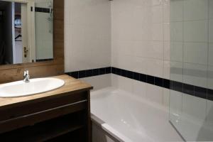 La salle de bains est pourvue d'une baignoire blanche et d'un lavabo. dans l'établissement Résidence Parc Des Airelles - Pièces 344, aux Orres