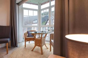 um quarto com uma mesa e uma grande janela em Gästehaus "Ursula" Hotel Garni em Bernkastel-Kues