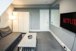 uma sala de estar com um sofá e uma televisão em HEART OF KENSINGTON AND CHELSEA,2 bedr em Londres