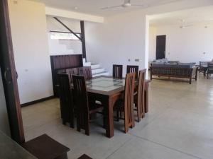 jadalnia z drewnianym stołem i krzesłami w obiekcie Nayan's Paradise Beach Villa w mieście Puttalam