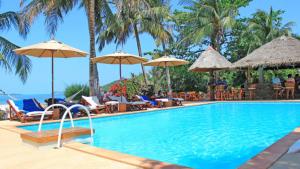 - une piscine avec des chaises longues et des parasols dans l'établissement The Waterfront Hotel at Fishermans Village, à Bophut 
