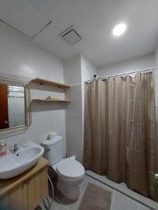 a bathroom with a toilet and a sink and a shower at Sweet Escape 16 in Bacolod